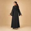 Back view of a black Moroccan djellaba with a pointed hood and triangular copper and teal sleeve panels