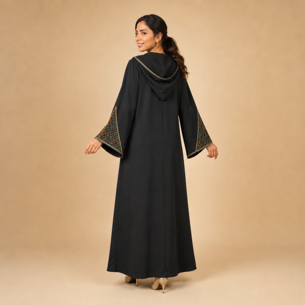 Back view of a black Moroccan djellaba with a pointed hood and triangular copper and teal sleeve panels