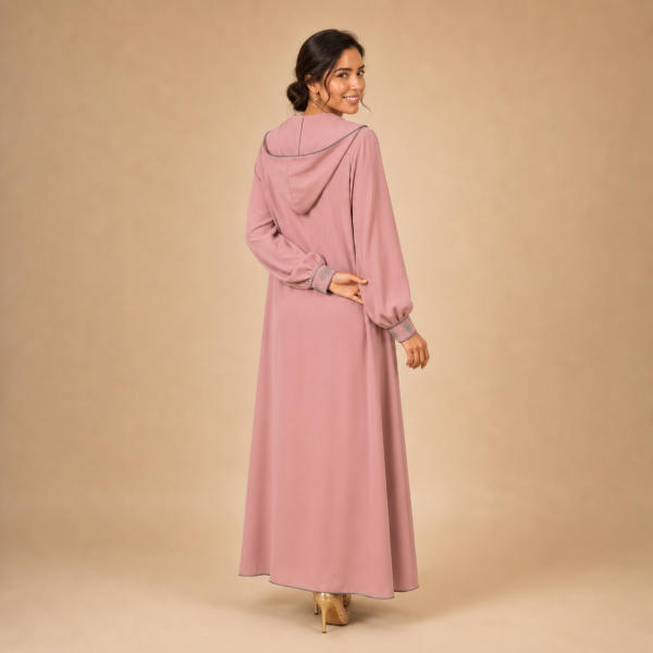 Back view of a dusty pink Moroccan djellaba with a pointed hood, grey edging and decorated cuffs