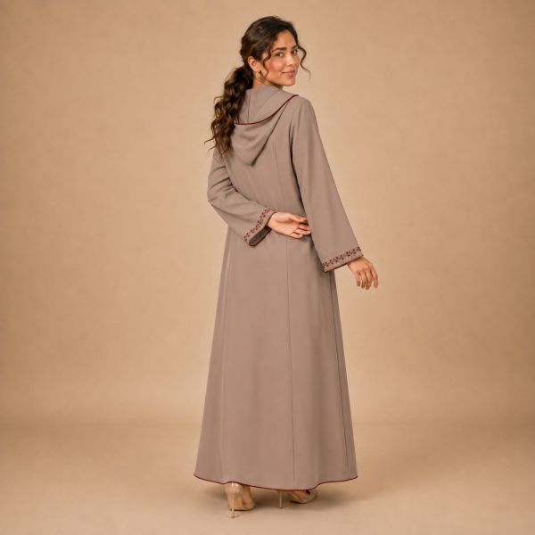 Back view of a warm taupe Moroccan djellaba with a pointed hood, burgundy edging and embroidered sleeve openings