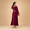 Side-angle view of the deep magenta Moroccan caftan showing its flowing silhouette and gold-trimmed cuffs
