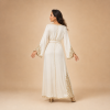 38 Back view of an ivory Moroccan caftan with gold sleeve details and an ornamental lower-side design
