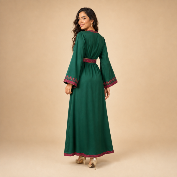 8 Side-angle view of the emerald green Moroccan caftan showing its flowing silhouette and decorated cuffs